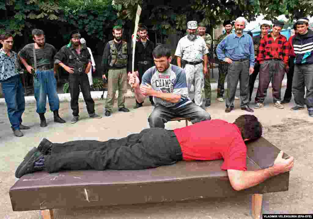 Бичуване на мъж в Грозни, 1996 г. Разрушенията на войната и относителната изолация след това създават в Чечня благодатна почва за екстремизъм. Насилието по улиците е основен проблем. През 1997 г. регионът приема Шариата и започват публичните екзекузии.&nbsp;