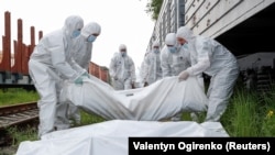 Trupurile soldaților ruși uciși în timpul războiului sunt încărcate de forțele ucrainene într-un vagon frigorific la Kiev. Imagine din 13 mai.REUTERS/Valentyn Ogirenko