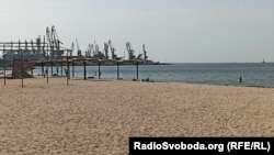 Бердянськ, пляж на узбережжі Азовського моря, вид на порт, серпень 2022 року