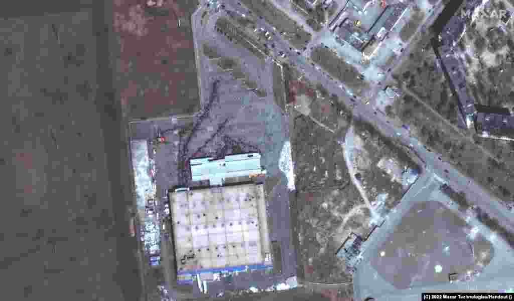 Цивільні жителі заблокованого російською армією Маріуполя стоять у черзі за їжею перед одним із останніх вцілілих магазинів міста, 29 березня 2022 року.&nbsp;Satellite image &copy;2022&nbsp;Maxar Technologies. Російські війська не пропускають продовольство, ліки та іншу допомогу до Маріуполя