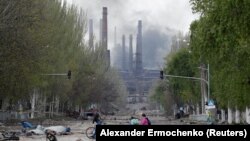 Луѓе со велосипеди во близина на фабриката Азовстал во Мариупол