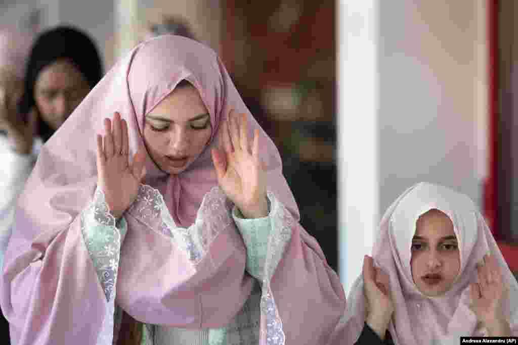 Женщина с ребенком во время молитвы на стадионе &laquo;Динамо&raquo; в Бухаресте, 2 мая&nbsp;