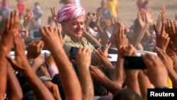 Masud Barzani, the current president of northern Iraq's semiautonomous Kurdish regional government, visits Syrian refugees at a camp in Irbil on August 19.