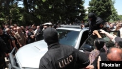 Armenia - Masked security officers are confronted by angry followers of the Armenian Apostolic Church in Echmiadzin, June 27, 2025.