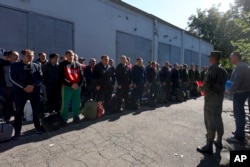 Recruți ruși stau lângă un centru de recrutare militară din Krasnodar, Rusia, pe 25 septembrie 2022.