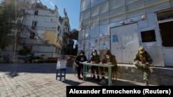 Украинанын Донецк облусундагы Мариупол шаарындагы референдум үчүн уюштурулган добушкана. Ар бир тилкеде орус аскерлери турду.