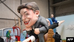 Car alegoric pregătit pentru carnavalul de la Köln (Germania): în față Elon Musk, în spate „prietena” sa din Germania, șefa partidului de extremă-dreapta AfD, Alice Weidel.