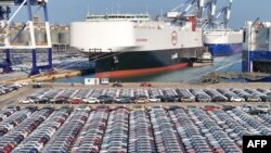 În imagine, mașini produse în China, pregătite pentru export, într-un port din provincia Shandong din estul Chinei.