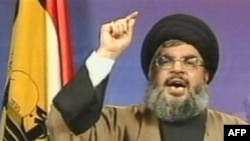 شیخ حسن نصرالله، رهبر حزب‌الله لبنان، در کنار پرچم این گروه