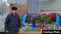 Нұрлыбек Қуанбаев 1986 жылғы Желтоқсан оқиғасы құрметіне қойылған ескерткіштің алдында тұр