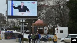 Ресей президенті Владимир Путиннің жыл сайынғы халыққа жолдауы Мәскеу аннексиялап алған Қырым түбегіндегі Севастополь қаласында үлкен ірі экраннан көрсетіліп жатыр. Ақпан айы, 2023 жыл.