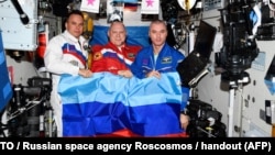 Алег Арцем'еў (зьлева) разам з іншымі расейскімі касманаўтамі трымае сьцяг так званай ЛНР пасьля пачатку паўнамаштабнай вайны Расеі супарць Украіны, 2022