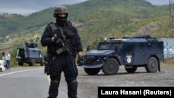 Një pjesëtar i Njësisë Speciale në Policinë e Kosovës, duke u kujdesuar për sigurinë, pas bllokimit të rrugës që çon në pikën kufitare në Jarinjë. Shtator 2021.