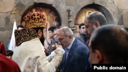 Armenia - Prime Minister Nikol Pashinian kisses a cross held by defrocked priest Stepan Asatrian during a ceremony at Hovanavank monastery, October 26, 2025.