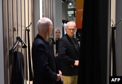 Ляўрэат Нобэлеўскай прэміі міру 2022 года Алесь Бяляцкі ў суправаджэньні жонкі Натальлі Пінчук прымярае новы касьцюм у гандлёвым цэнтры ў Вільні, 14 сьнежня 2025 года, на наступны дзень пасьля вызваленьня з турмы