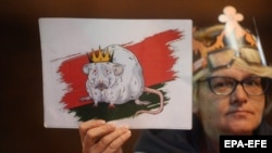 Вечерта след тайната церемония протестиращите носеха плакати, на които Лукашенко е изобразен като мишка с корона