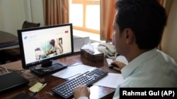 Ahmad Khalid Fahim, program director for the Swedish Committee for Afghanistan shows the group's website during an interview with The Associated Press in Kabul on July 17.