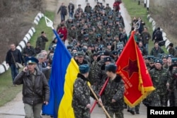 Летчики 204-й бригады тактической авиации ВСУ идут колонной с государственным флагом Украины и боевым знаменем авиабригады, март 2014 года