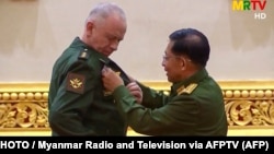 Russia's Deputy Defense Minister Aleksandr Fomin (left) receives a medal from Burma's armed forces chief, Senior General Min Aung Hlaing, on March 26.