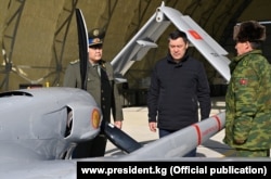 Президент Садыр Жапаров (в центре) и глава ГКНБ Камчыбек Ташиев (слева), город Джалал-Абад, 18 декабря 2021 г.