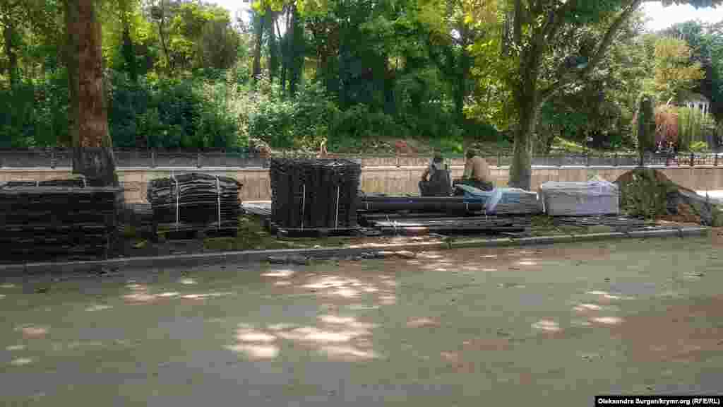 İşçiler kölgede eski taşlarda raatlana