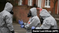 British military personnel work to remove vehicles from a cordoned off area behind a police station in Salisbury near the place where the Skripals were poisoned in March 2018.