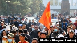 Өлкөнүн туусун көтөргөн кыргызстандыктар. Сүрөттүн макалага тиешеси жок. Акциялардын биринде тартылган, октябрь, 2020-жыл. 