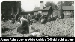 Foametea indusă de Stalin în Uniunea Sovietică - țărani înfometați și obosiți așteaptă pe calea ferată din Harkov, în 1932. Ftografie de James Abbe.