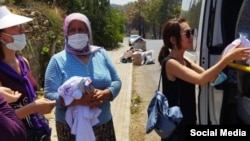 Периза Асаналиева айылдыктарга жардам таратып жатат.