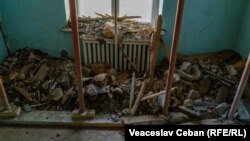 Resturi de tavan căzute într-un fost salon.