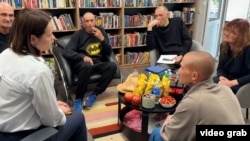 Liderul opoziției din Belarus, Svetlana Țihanovskaia (în stânga), la întâlnirea cu deținuții eliberați, inclusiv cu fostul jurnalist al Europei Libere Ihar Karnei (al treilea din stânga), în Lituania.