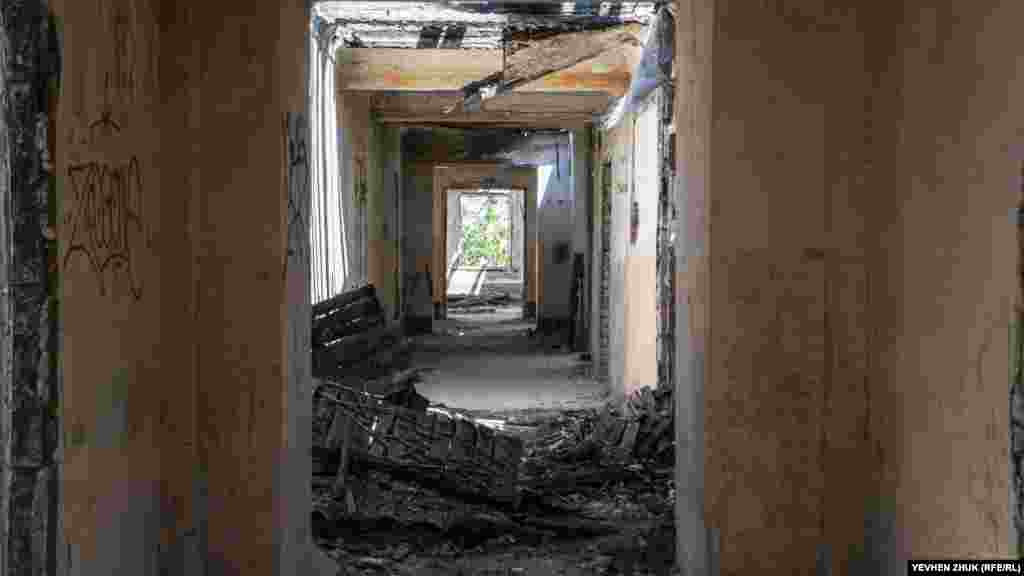 У коридор падає сонячне світло через дірки в даху