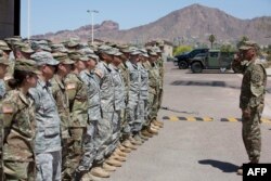 Membri ai Gărzii Naționale din Arizona ascultă instrucțiuni, la Rezervația militară Papago Park din Phoenix. 9 aprilie 2018. În timpul primului mandat, Donald Trump a ordonat combaterea traficul de droguri și imigrația ilegală.