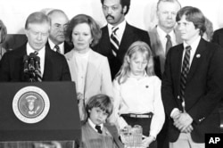 Președintele Jimmy Carter, însoțit de soția sa Rosalynn, fiica Amy și nepotul Jason, în timpul discursului prin care recunoștea victoria în alegeri a contracandidatului republican, Ronald Reagan. 4 noiembrie 1980.