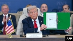 Прэзыдэнт ЗША Дональд Трамп паказвае падпісаны дакумэнт на саміце ў эгіпецкім Шарм-эш-Шэйху 13 кастрычніка 2025