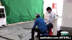 Illýustrasiýa suraty. Oturgyçda oturan maskaly adamlar. Aşgabat. Awgust, 2020.