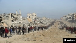 Palestinieni strămutați își croiesc drum printre dărâmături în timp ce încearcă să se întoarcă la casele lor după o amânare a încetării focului între Israel și Hamas cu privire la lista ostaticilor, în nordul Fâșiei Gaza, 19 ianuarie 2025.