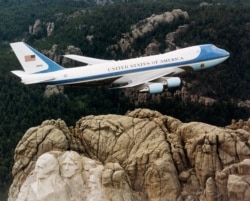 Air Force One ady bilen tanalýan iki sany Boeing 747 uçarlarynyň biri ABŞ-nyň Günorta Dakota ştatyndaky Raşmor daglarynyň üstünden uçup barýar. 2001 ý.