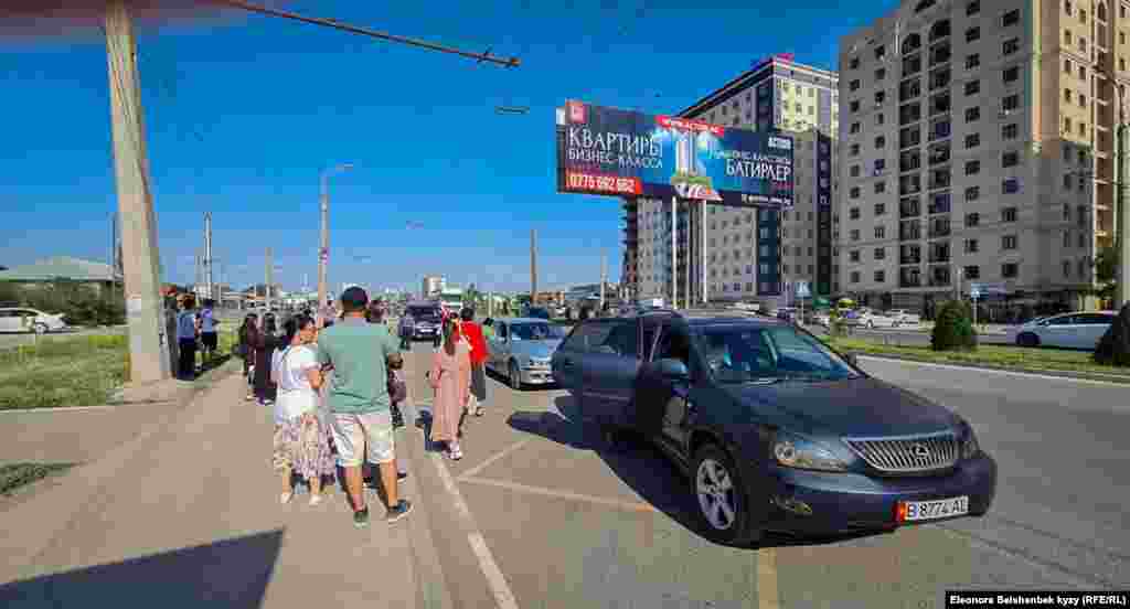 >Аялдамада транспорт күткөн шаардыктар.