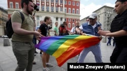 Protesters try to tear a rainbow flag during an LGBT community rally in central Moscow in May 2015.
