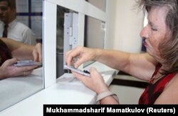 Женщина пересчитывает деньги в филиале Национального банка Узбекистана в Ташкенте, 5 сентября 2017 года.