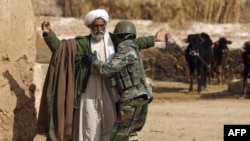 An Afghan soldier frisks a farmer during a patrol near Marjah. Can the Afghan government and its NATO allies win public support there?