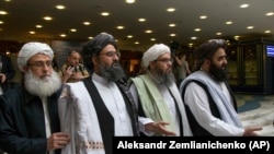 FILE: Mullah Abdul Ghani Baradar, a top Taliban leader, second from left, arrives for talks in Moscow in May 28.