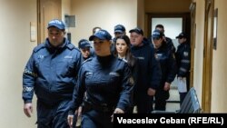 Полицейские ведут Евгению Гуцул на заседание суда Буюкан.