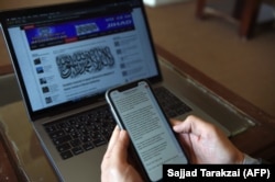Un reporter afgan se uită la mesajele trimise de purtătorul de cuvânt al talibanilor, Zabihullah Mujahid, în redacția postului de televiziune Maiwand din Kabul (foto de arhivă).