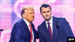 Activistul de dreapta Charlie Kirk vorbește pe scenă cu președintele Donald Trump la America Fest 2024 în Phoenix, Arizona. 22 decembrie 2024.