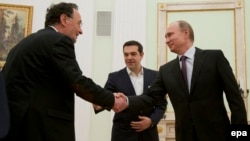 Президент РФ Володимир Путін обмінюється рукостисканням з (на той час) міністром енергетики Греції Панайотисом Лафазанісом, поруч із яким стоїть тодішній прем'єр-міністр Греції Алексіс Ципрас. Москва, 2015 р. У 2023 Лафазаніс заснував проросійську партію ДІКЕА.