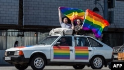 Gay-rights activists hold rainbow flags on top of a car during a protest in central Moscow on May 31.