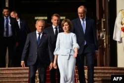 Президент Молдовы Майя Санду ведет премьер-министра Польши Дональда Туска, президента Франции Эмманюэля Макрона и канцлера Германии Фридриха Мерца на празднование Дня независимости страны. Кишинев, 27 августа 2025 года