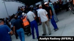 Daň säher bilen bankomat nobatynda duran adamlar. Mary